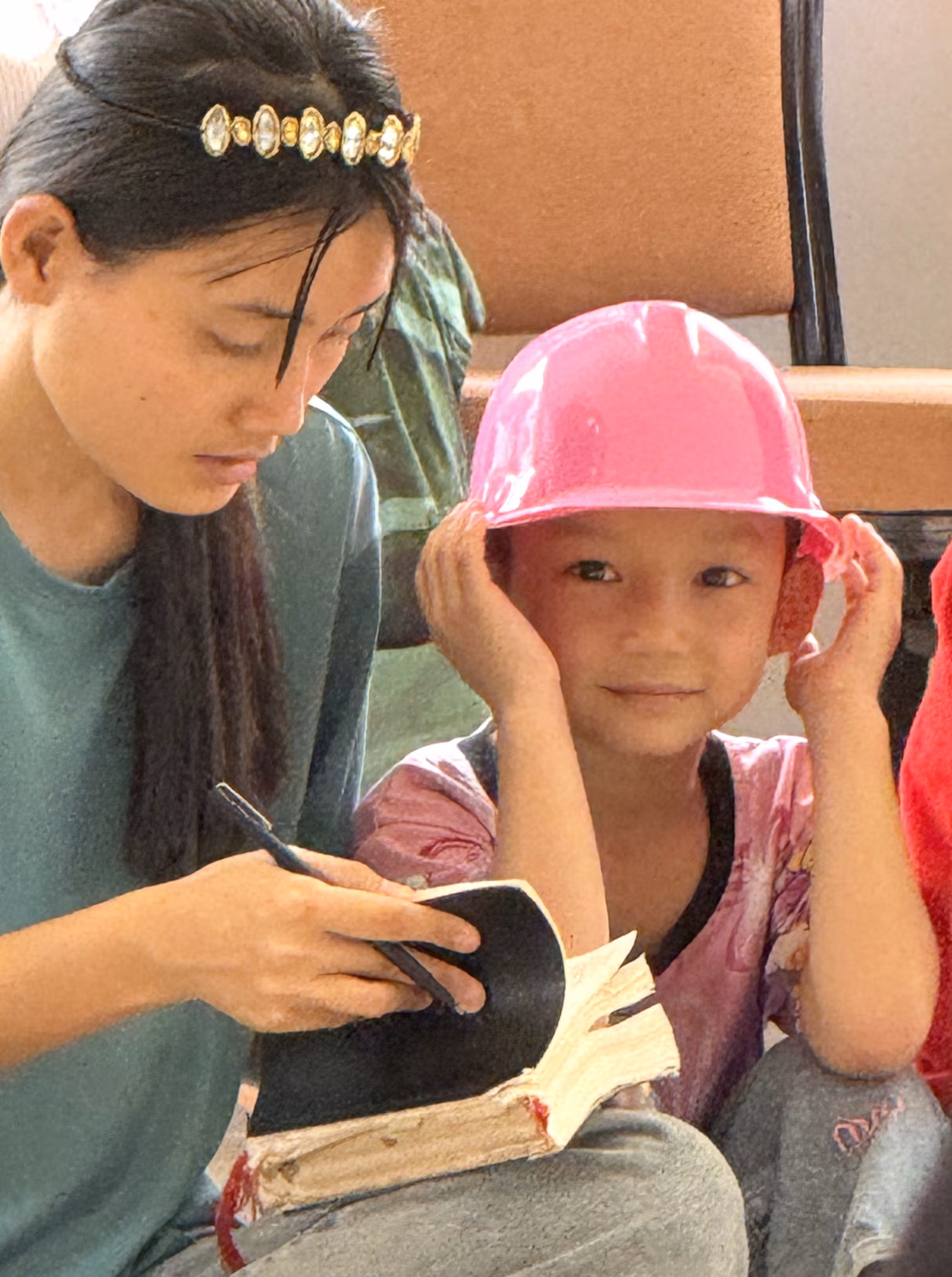 Naw Mua Wah, the youngest girl at Faith House, wearing her pink construction hat